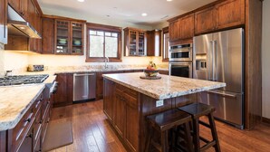 A modern kitchen with wooden cabinets, stainless steel appliances, and a granite countertop. - Private Home with Hot Tub! Mountain Views! Short walk to Village! (Mammoth Lakes)