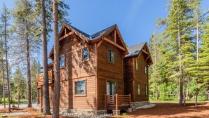 A wooden cabin with a balcony, surrounded by trees. - Private Home with Hot Tub! Mountain Views! Short walk to Village! (Mammoth Lakes)
