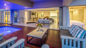 Un espacio moderno con piscina, comedor y un dormitorio con cama grande y armario.