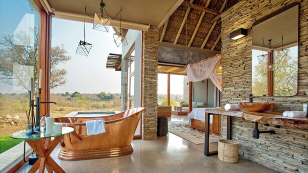 Une salle de bain moderne avec une grande baignoire, un meuble-lavabo en bois et un grand miroir.