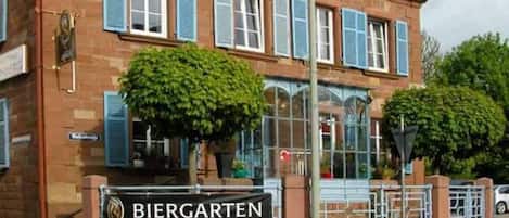 Un edificio con un letrero que dice "BIERGARTEN" y fachada de ladrillo.
