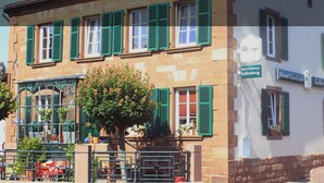 A traditional European building with green shutters, a sign for 'Hotel Gasthaus Gellenberg', and a tree in the foreground. - Hotel Gasthaus Gellenberg (Rehlingen-Siersburg)
