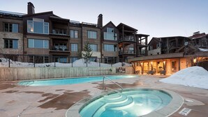 A modern building with a pool area, including a hot tub and a standard pool.