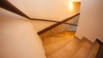 Un escalier avec une rampe en bois et un mur en pierre à sa base.