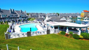 A resort with a large swimming pool, multiple guest rooms, and a marina.