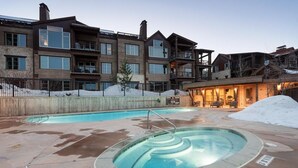 Un immeuble à plusieurs étages doté d’un espace piscine comprenant un jacuzzi et une piscine classique.