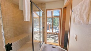 Enjoy a refreshing shower in this bathroom with a glass enclosure and patio access.