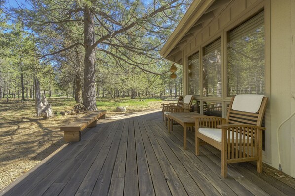 Relax on the cabin's spacious deck, surrounded by trees and offering views of the forest.