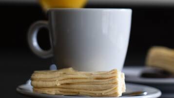 Un desayuno con una taza y una pila de tortitas en un plato.
