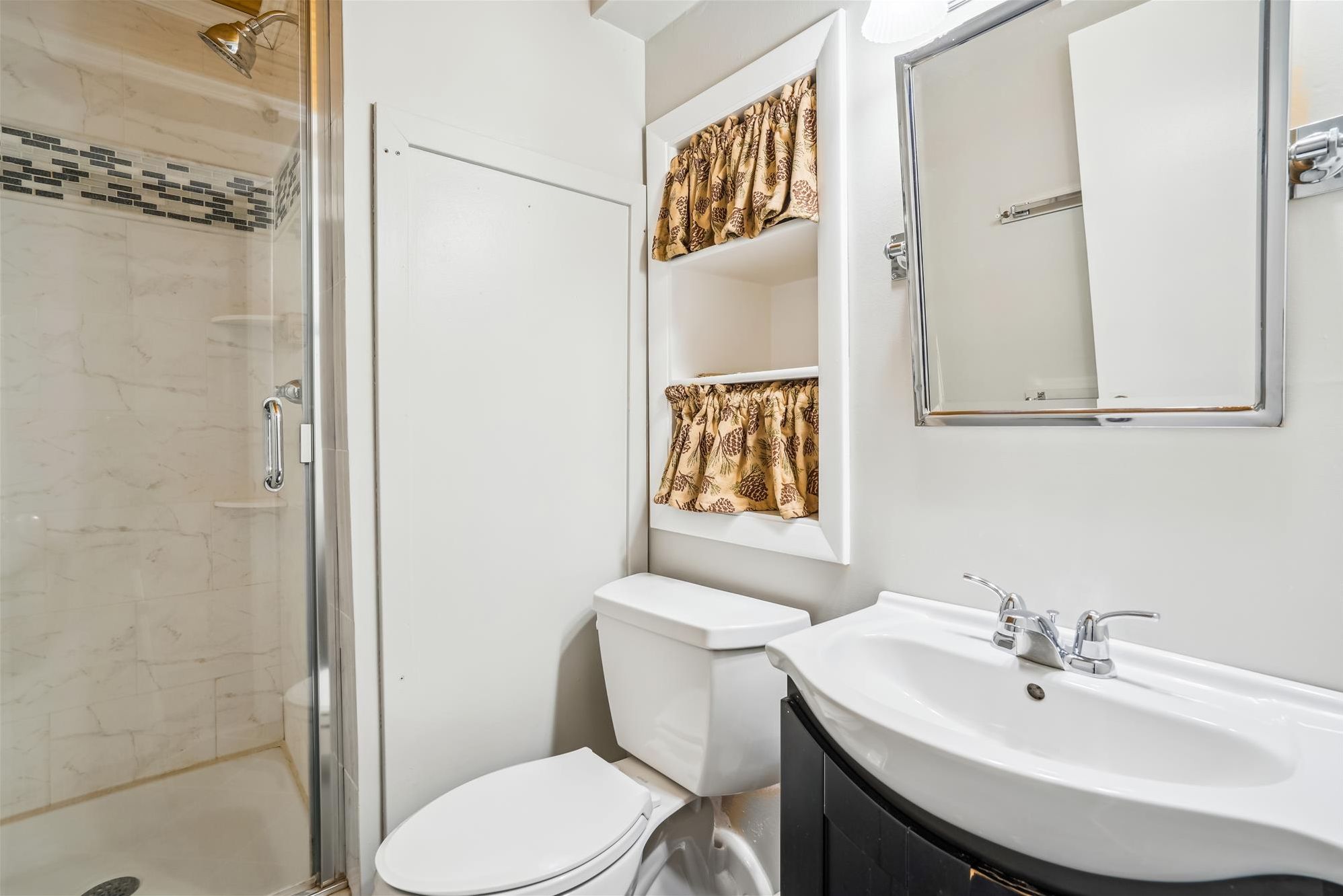 Freshen Up - The updated bathroom features a walk-in tiled shower and modern finishes.