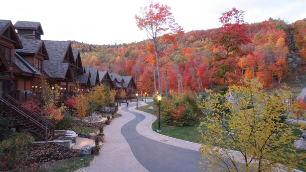 A lodge with a winding pathway, wooden buildings, and autumn foliage. - BEST Ski-in / ski-out in Tremblant!!!  CHIC chalet overlooking ski slopes!
   
  (Mont-Tremblant)
