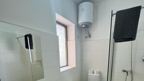 A modern bathroom with a sink, toilet, and shower. - The Triton (St. Paul's Bay)