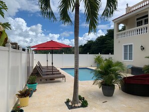 Relax by the pool surrounded by lush greenery and tropical plants.