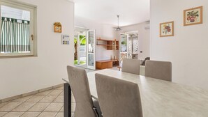 Un comedor con una mesa, sillas, un reloj y cuadros en la pared.