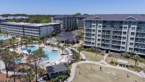 Um hotel com vários edifícios, piscina e áreas de estar ao ar livre.