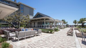 Hotel com área de estar ao ar livre, alpendre coberto e vista clara para a praia.