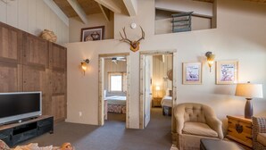 A cozy living room with a television, a plush armchair, and a patterned rug. - Seasonal Pool | Pickleball | Hot Tub (Ketchum)