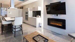 A modern kitchen with a flat-screen TV and a fireplace. - Duplex Loft with Private Terrace, Parc Avenue (Montréal)