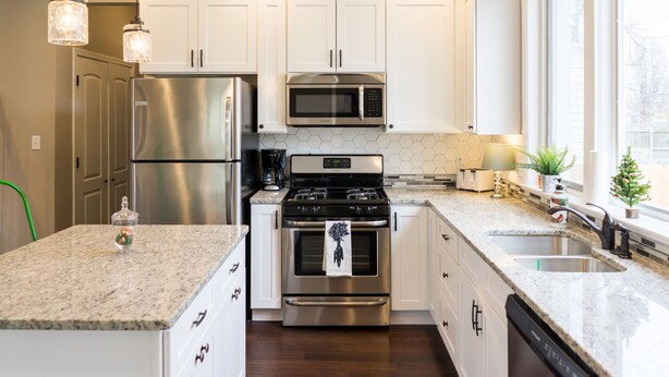 A modern kitchen with white cabinets, stainless steel appliances, and a granite countertop. - Urban Farmhouse - 3BR 2.5 BA (5 Beds) Near TG Park & Central to Everything! (St. Louis)
