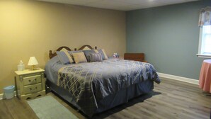 A bedroom with a bed, nightstand, lamp, and a window with curtains. - Gorgeous Mtn Views, Perfect for Fall, Near Peaks of Otter, D-Day Memorial (Bedford)