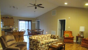 A spacious living room with a patterned sofa, two armchairs, a wooden coffee table, and a dining area with chairs and a table. - Gorgeous Mtn Views, Perfect for Fall, Near Peaks of Otter, D-Day Memorial (Bedford)