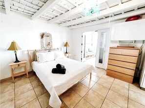 A bedroom with a bed, bedside tables, a dresser, and a mirror.