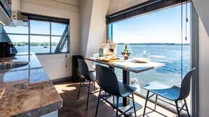 A modern kitchen with a large window overlooking a body of water. - Numa Amsterdam The Crane (Amsterdam)