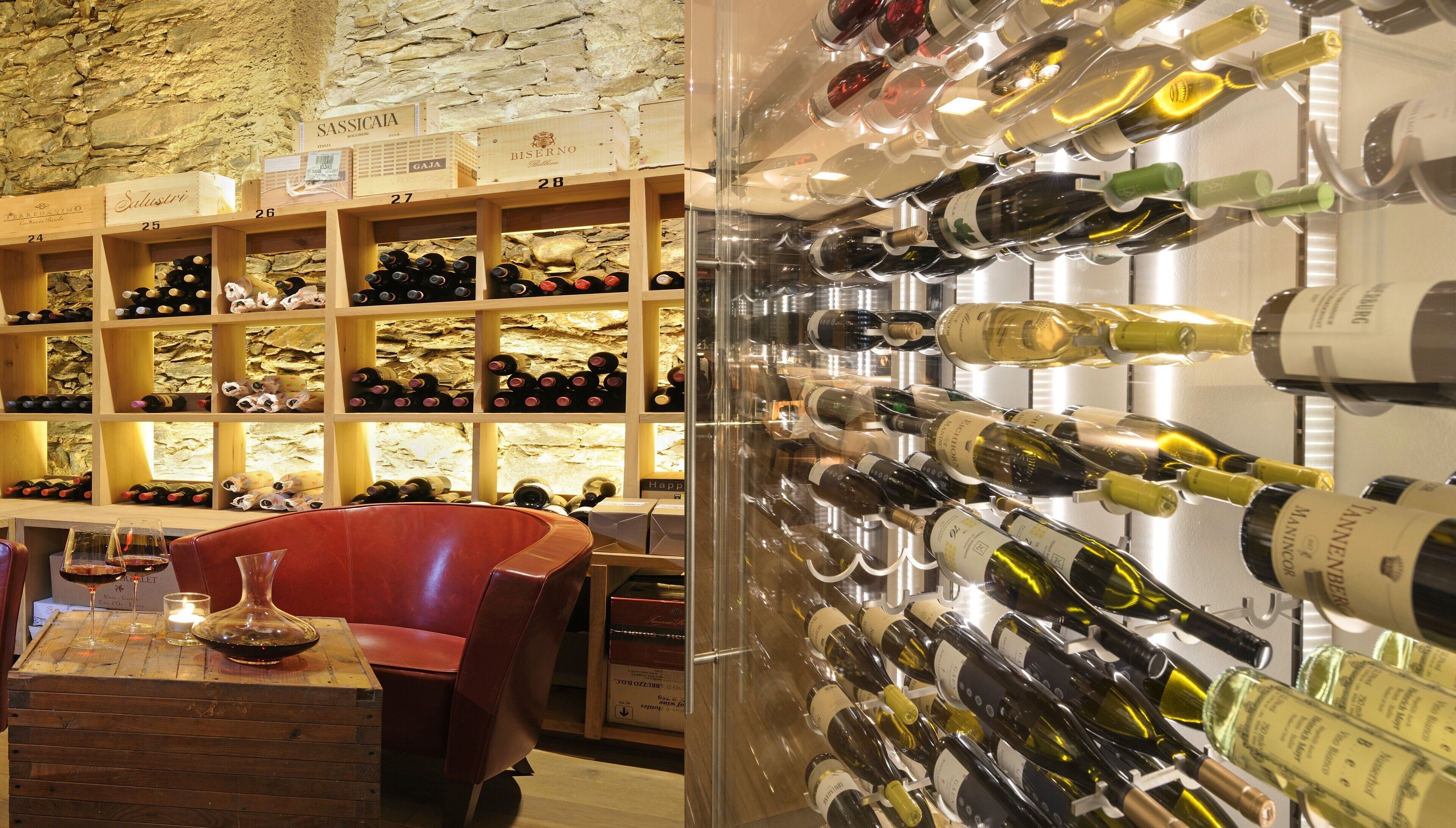 Una bodega con estantes de madera y una vitrina de vidrio llena de botellas de vino.