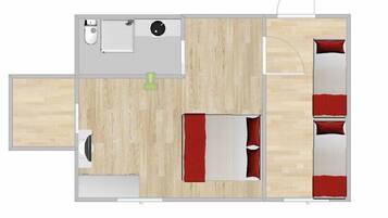 Una habitación con cama, una mesita, una silla y una ventana.