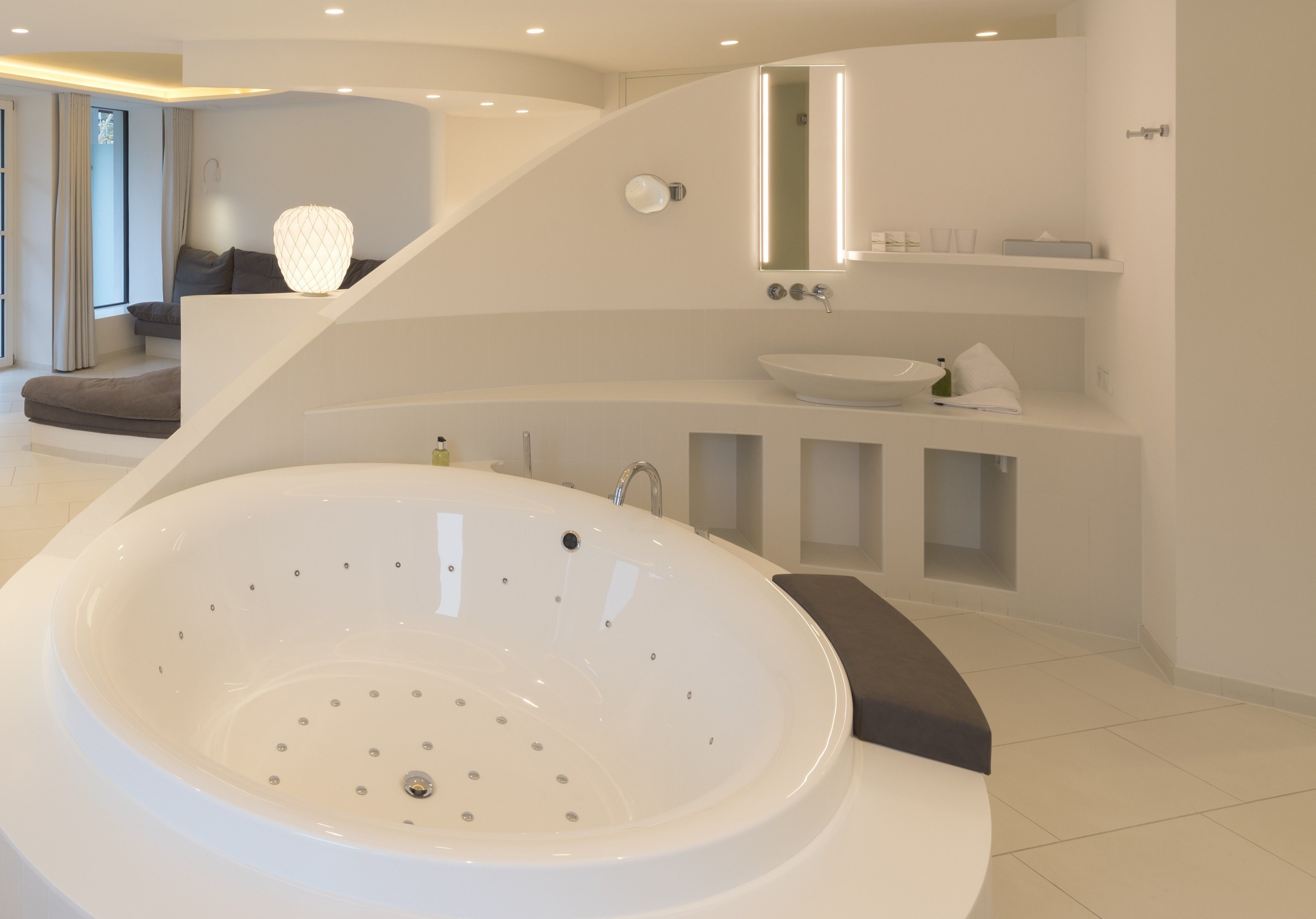A modern bathroom with a freestanding bathtub, a vanity with a sink, and a mirror.