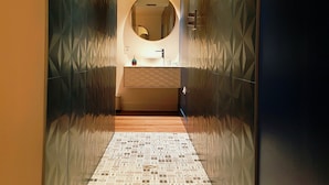 A hallway with patterned walls, a mirror, and a sink. - Les Granges de Jules (Lafitte-Vigordanne)