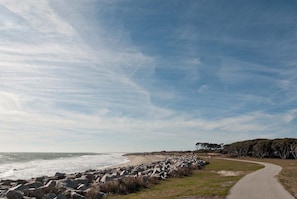 Walk along the paved path, bordered by a low wall, and enjoy the scenic views of the rocky shoreline.