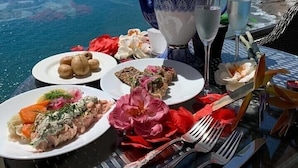 Une table dressée avec de la nourriture et des boissons, offrant une vue sur la côte.