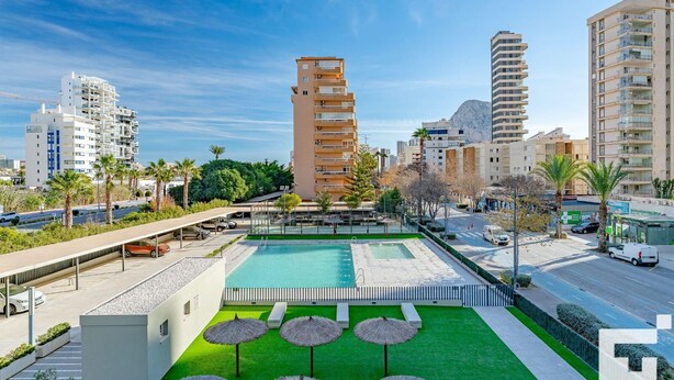 A modern hotel with a rooftop pool, surrounded by palm trees and urban buildings. - El Mirador de Calpe 2E - Grupo Turis - Calpe, Costa Blanca (Calpe)