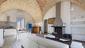 Un vaste espace de vie doté d’un haut plafond en arc de cercle, d’une cuisine moderne et d’un coin salon confortable.