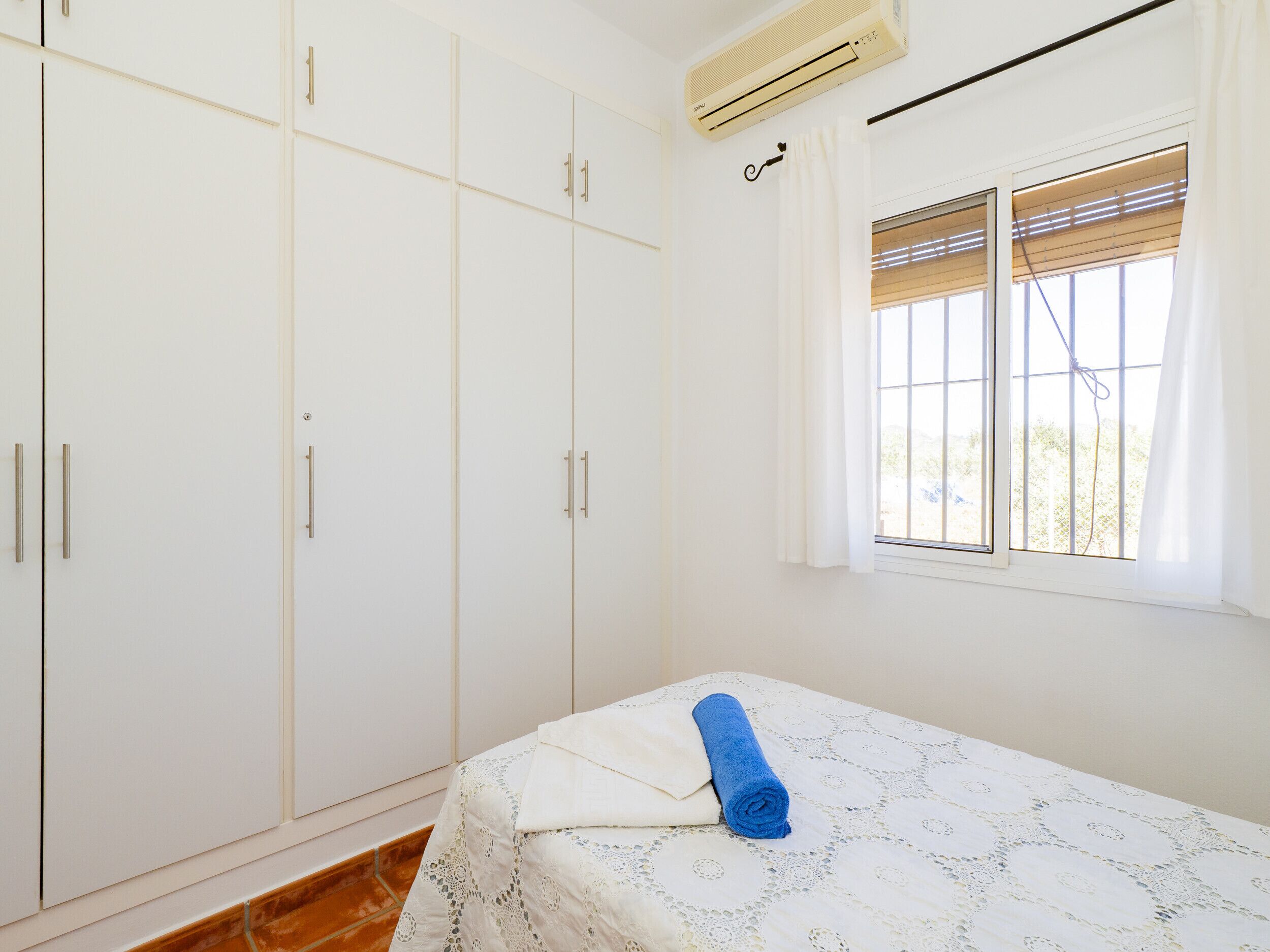 Una camera da letto con un letto, una finestra con tende e un armadio.