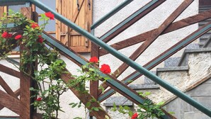 A staircase with a wooden railing, a stone wall, and a wooden door. - House in the woods Osiglia, Liguria (Osiglia)