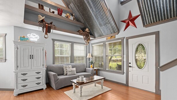 Un salón con sofá gris, mueble blanco, mesa de centro de madera y una decoración con estrella roja.