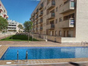 Enjoy a refreshing swim in the pool surrounded by lush greenery and a beautifully maintained lawn.