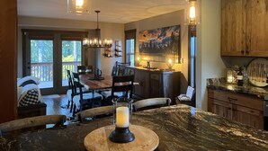 Une cuisine spacieuse avec un coin repas, des meubles en bois et une grande fenêtre donnant sur l’extérieur.