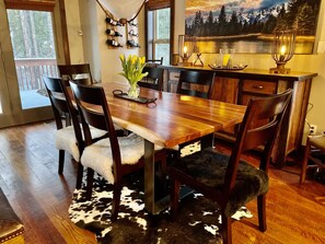 A dining area with a wooden table, chairs, and a cowhide rug. - Beautiful Home on Home Again Trail 3BR ski in-out. 5 star home, 5 star location (Whitefish)