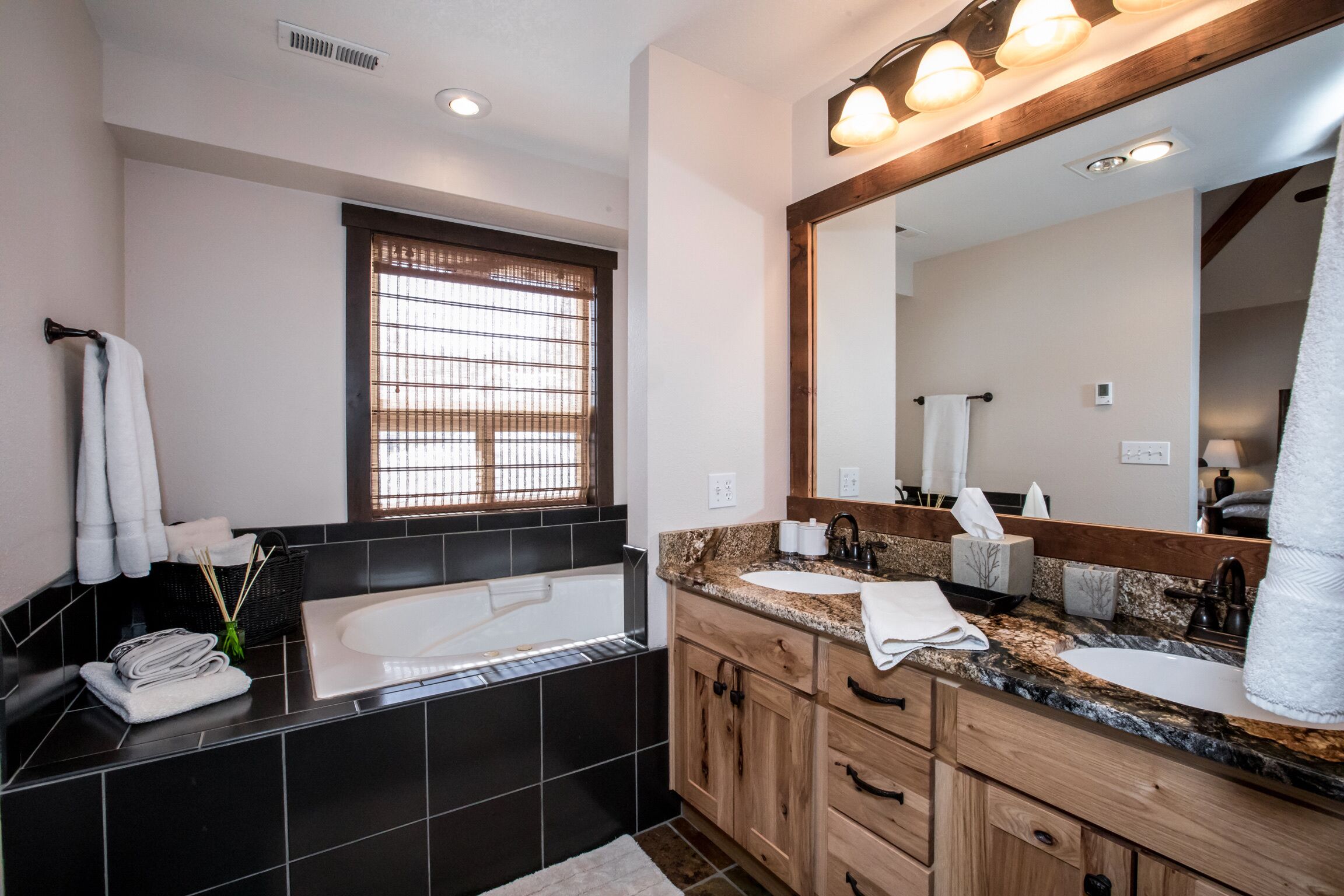 Un baño moderno con una bañera grande, un lavamanos y un espejo.