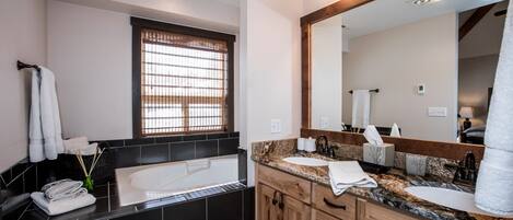 Un baño moderno con una bañera grande, un lavamanos y un espejo.