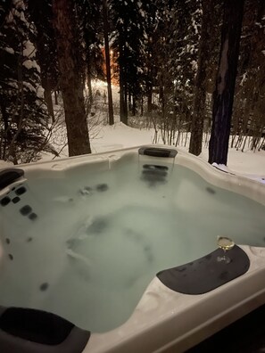 A hot tub surrounded by snow-covered trees. - Beautiful Home on Home Again Trail 3BR ski in-out. 5 star home, 5 star location (Whitefish)