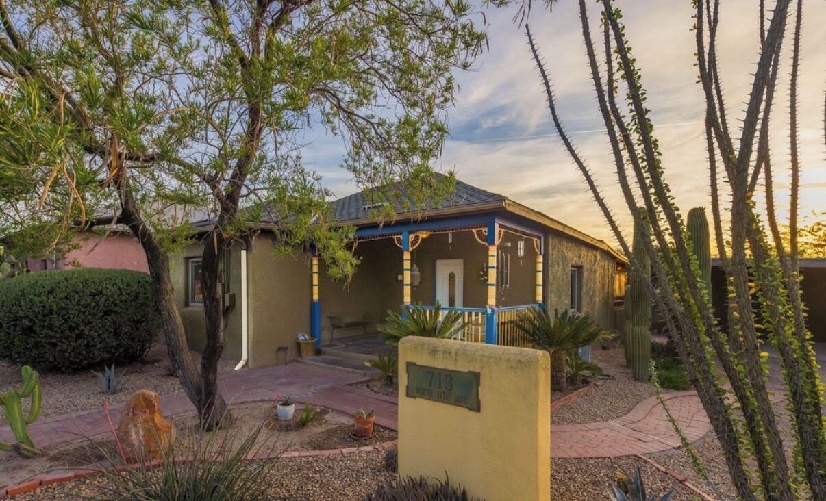 Un edificio con un patio techado, rodeado de cactus y plantas de desierto.