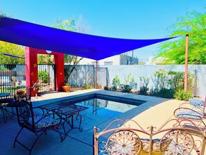 A backyard with a swimming pool, patio furniture, and a pergola providing shade. - Artsy Historic Downtown 2BR w large backyard & private Salt Water Spa Pool (Tucson)