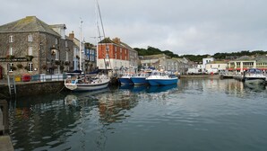 A harbor with boats docked, stone buildings, and a sign for 'Old Custom House'.