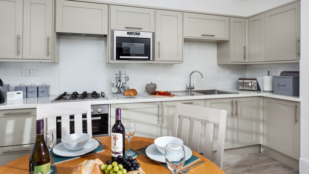 A modern kitchen with a built-in oven, gas stove, and stainless steel appliances.