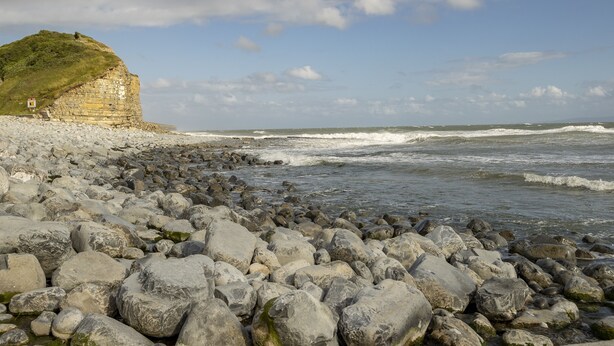 A rocky beach with large boulders and a cliff with a grassy top. - Ariel, Marcross, Llantwit Major , Vale of Glamorgan, Wales (Marcross)