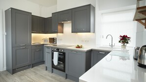 A modern kitchen with grey cabinets, a built-in oven, and a white countertop. - Ariel, Marcross, Llantwit Major , Vale of Glamorgan, Wales (Marcross)